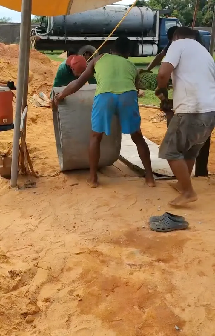Community workers installing a concrete well ring