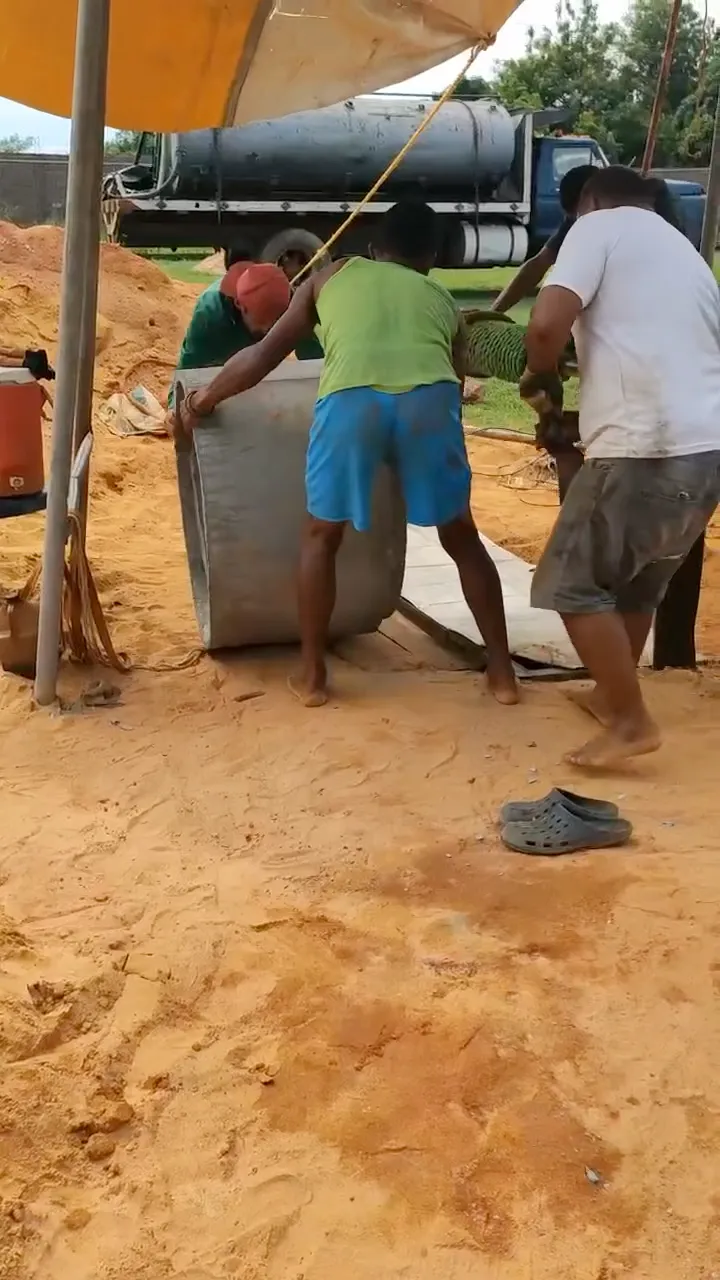 Community workers installing a concrete well ring